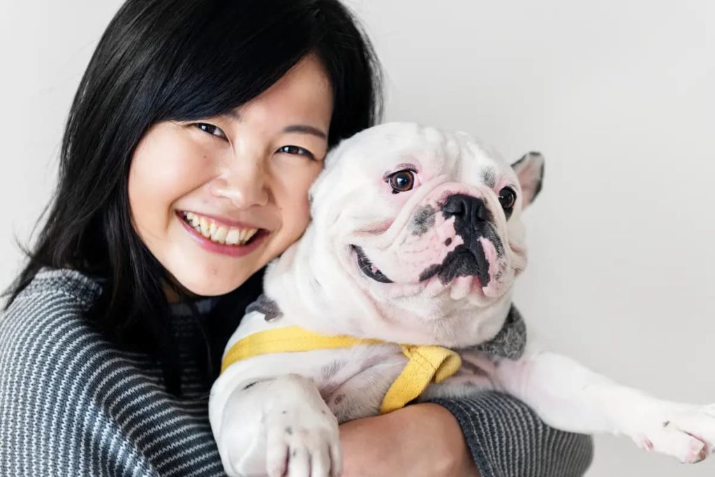 asian woman hugging her little dog